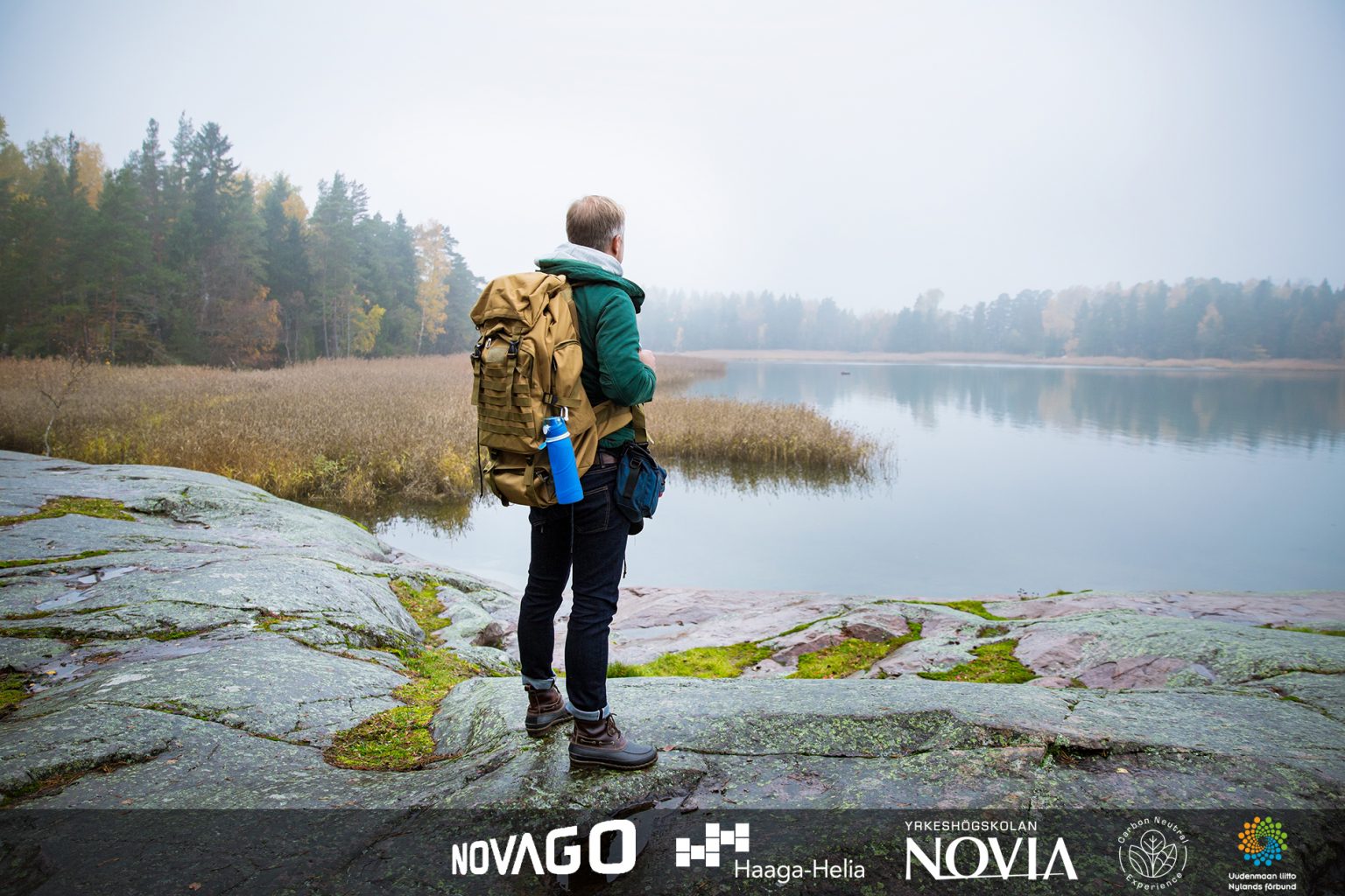 Mature man exploring Finland in the fall, looking into fog. Hike